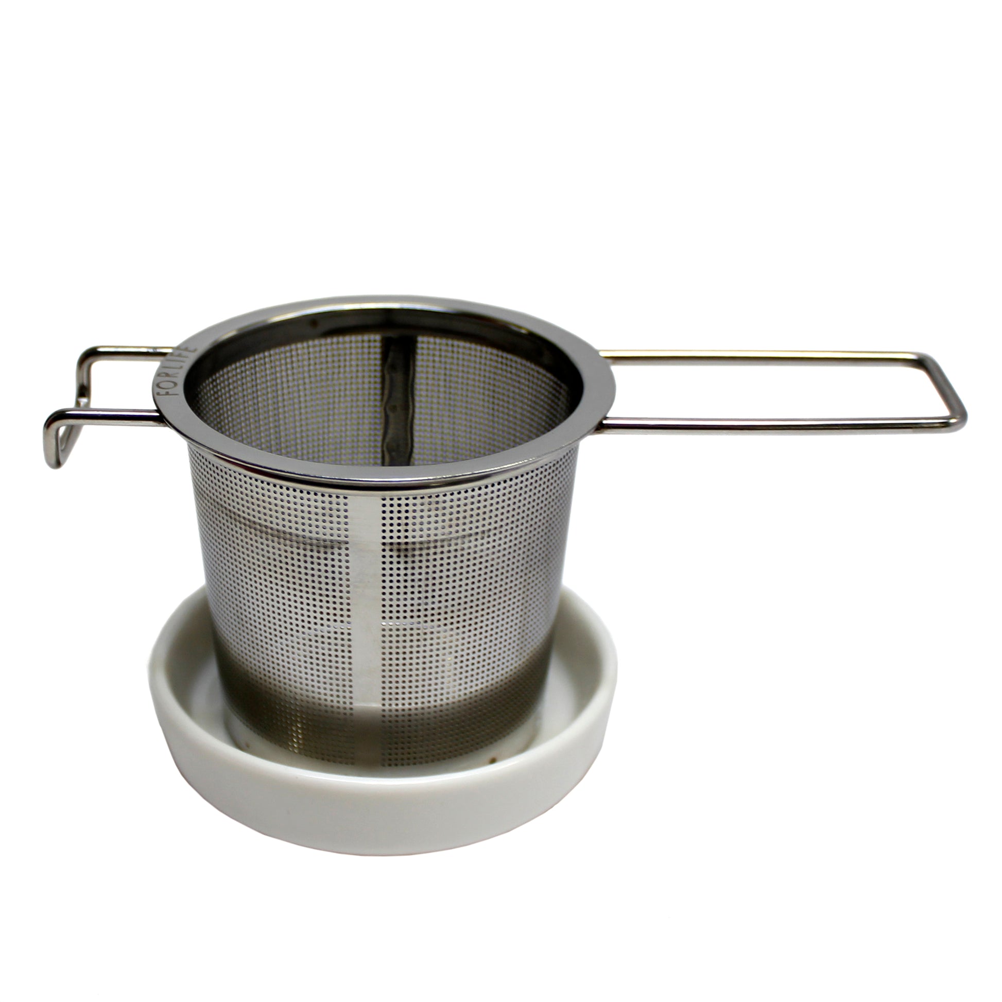 A stainless steel tea strainer with tiny holes, accompanied by a white ceramic basket rest.