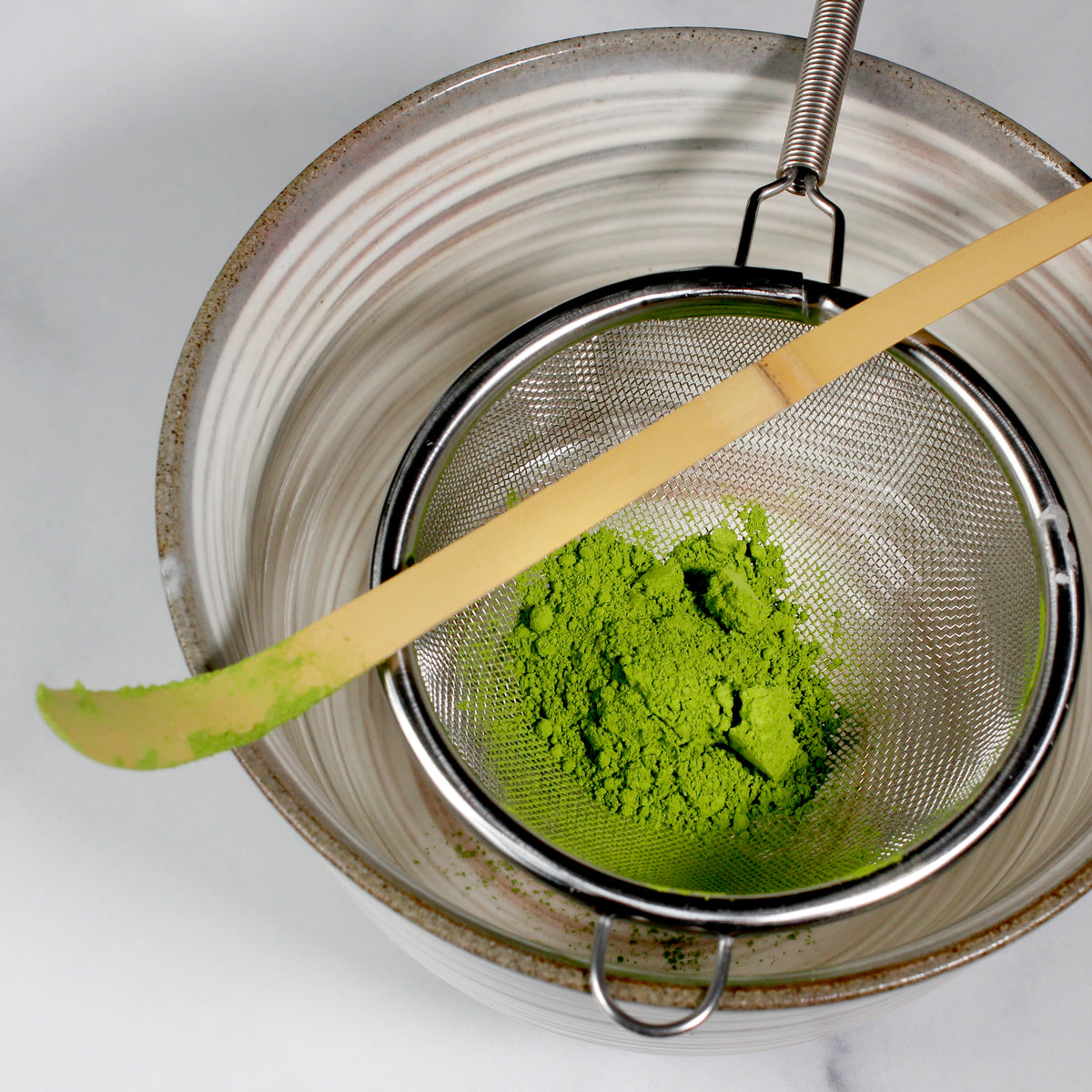 Aoarashi Ingredient Grade Matcha - Marukyu Koyamaen - Uji, Kyoto, Japan - powder in a shifter with a Matcha scopp over a Matcha bowl. Tasting Notes:
baby spinach • cucumber • split pea