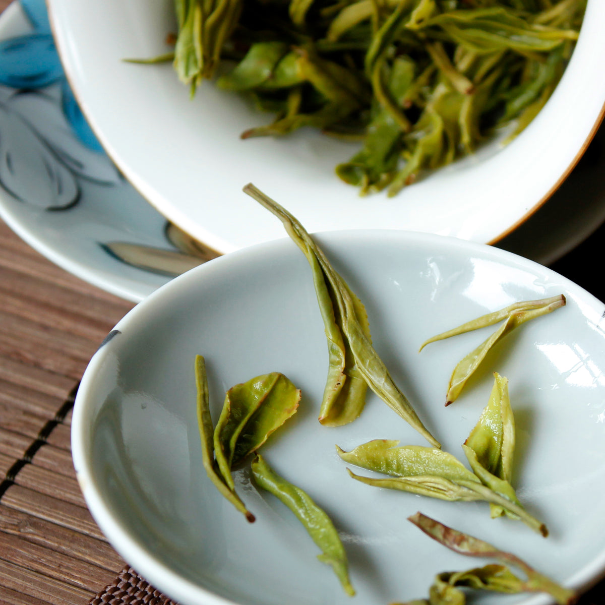 Close up of wet large leaves on the lid on the Gaiwan, the Gaiwan is tipped to the side to show the rest of the leaves.