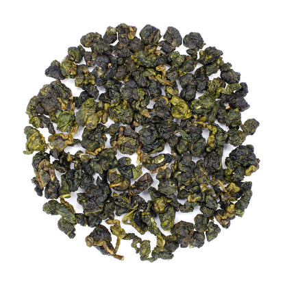 Loose pile of Golden Buds Milk Oolong: Jin Xuan on a white background. Ingredients: Camellia sinensis leaves.