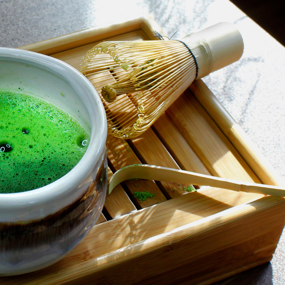 Bamboo Matcha Whisk - Chasen - with matcha set showing the matcha bowl, scoop and tray on a grey surface. 