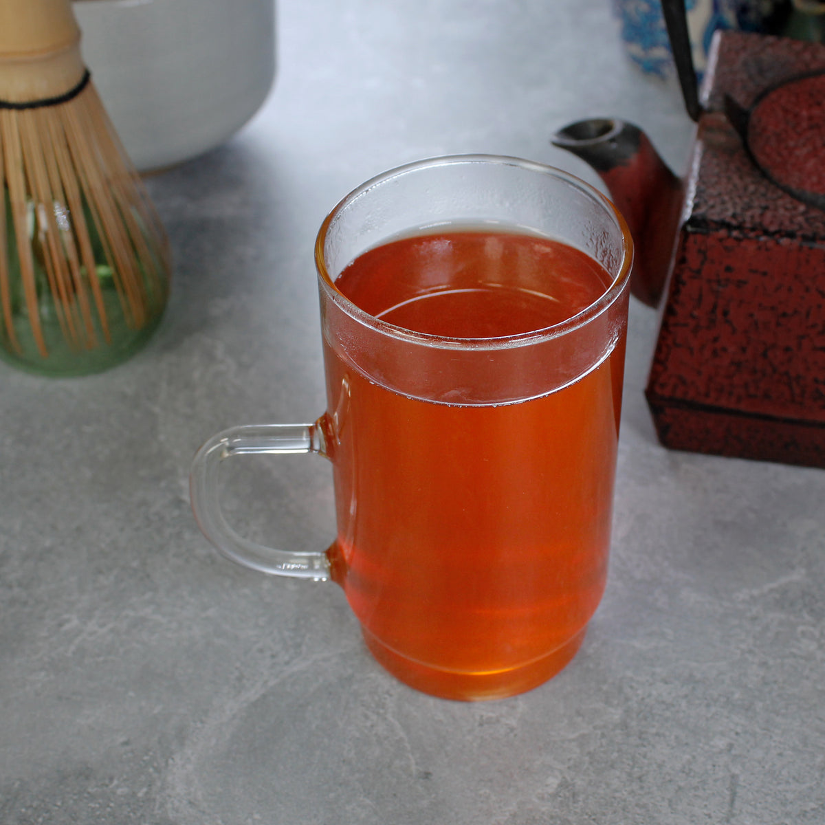 Pumpkin Spice - infusion in a tall glass, a square red tea pot and matcha whisk in the background. Tasting Notes:
cinnamon • nutmeg • pumpkin