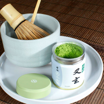 Yugen Ceremonial Grade Matcha - Marukyu Koyamaen - Uji, Kyoto, Japan - open tin with Matcha accessories surrounding it. Tasting Notes:
broccoli • asparagus • white bean